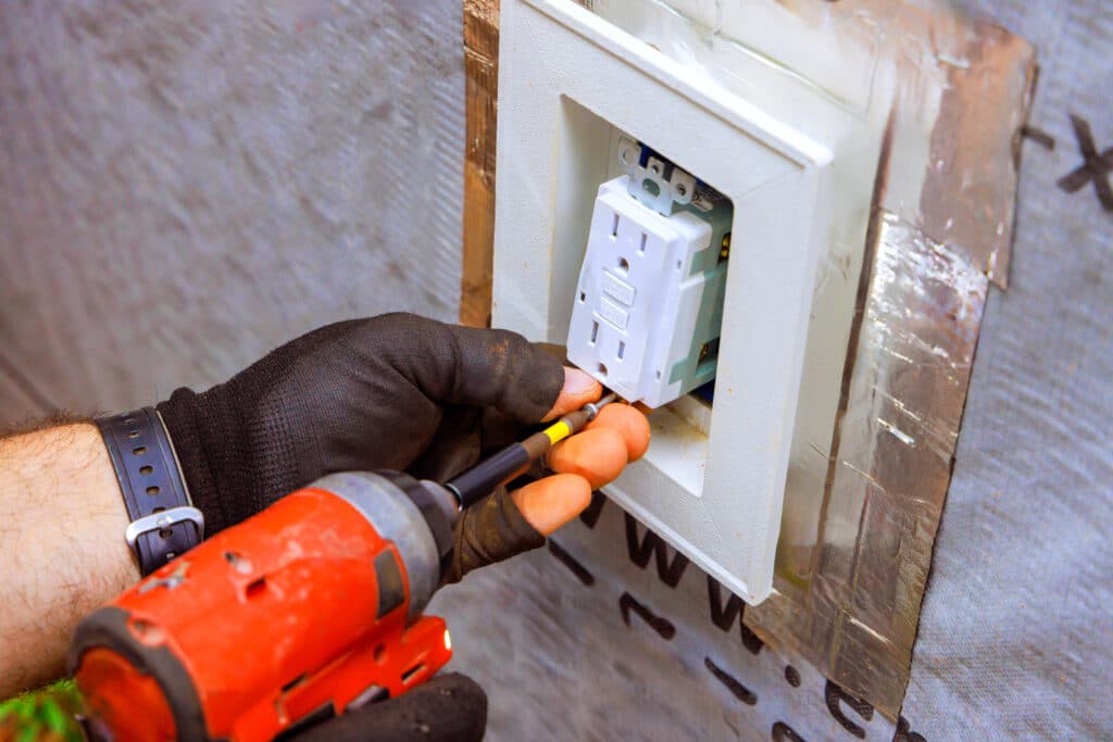 Licensed electrician installing a GFCI outlet for home electrical safety