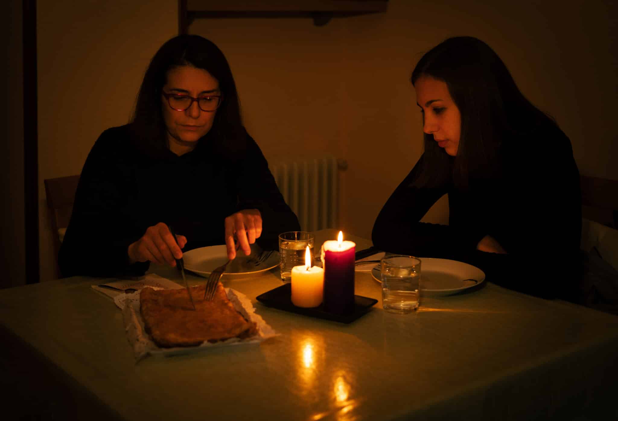 One-parent family dining by candlelight. Blackout concept, Residential Power Outages.